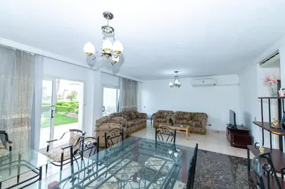 a living room with a glass table and chairs at Hurghada Khaligeya village in Hurghada