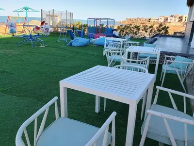 a group of white tables and chairs with a playground at Fanadir bay compound in Hurghada