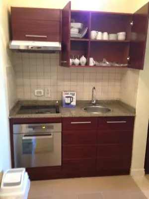 a kitchen with wooden cabinets and a sink at Cozy studio with a view in port ghalib in Marsa Alam
