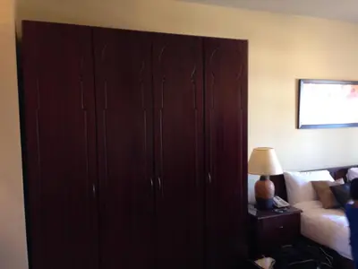 a large wooden cabinet in a bedroom with a bed at Cozy studio with a view in port ghalib in Marsa Alam