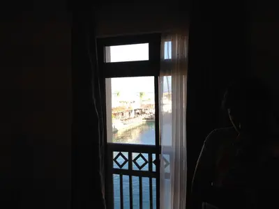 a person looking out a window at a canal at Cozy studio with a view in port ghalib in Marsa Alam