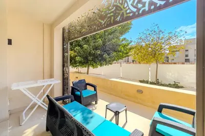 a room with a large window with chairs and a table at Homestyle & Summery 1BDR Mangroovy Free Beach Pool in Hurghada