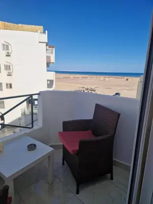a chair on a balcony with a view of the beach at Tiba View in Hurghada
