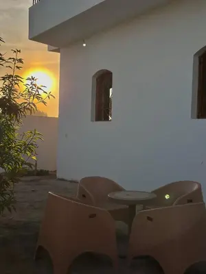 a table and chairs in front of a white wall at Hubo in Al Aqālitah