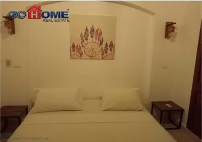 a bed in a room with two tables at Comfortable 1 Bedroom at Sabina El-Gouna Y160 in Hurghada