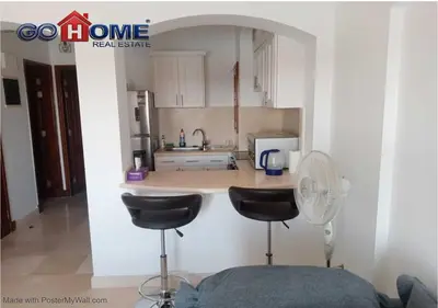 a kitchen with a counter with two stools and a fan at Comfortable 1 Bedroom at Sabina El-Gouna Y160 in Hurghada
