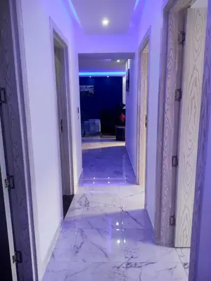 a hallway with white walls and marble floors and doors at Fanadir Bay Compound in Hurghada