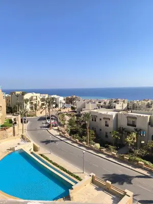a view of a city with a swimming pool and the ocean at Elite 3bdr apartment with garden beside corral reef in Hurghada