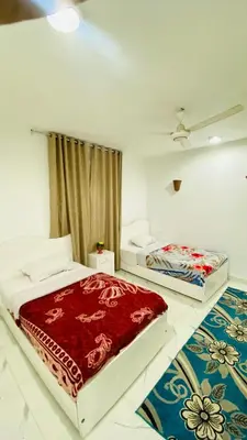 a bedroom with two beds and a red blanket at Menna guest house in Luxor