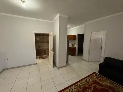 an empty living room with a couch and a kitchen at The Highlander in Al Karnak