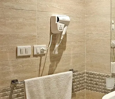a bathroom with a hair dryer on a wall at Elhambra First Avenue in Hurghada