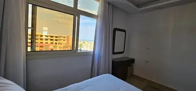 a bedroom with a window with a view of a building at Elhambra First Avenue in Hurghada