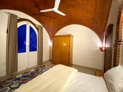 a bedroom with a bed and a ceiling with a window at ELamir house in Al Aqālitah