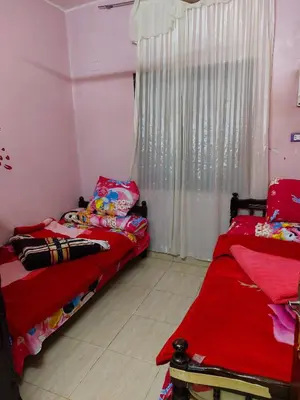 two twin beds in a room with a window at Mahmoud's House in Al Manshīyah