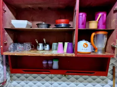 a shelf with cups and other items on it at Mahmoud's House in Al Manshīyah