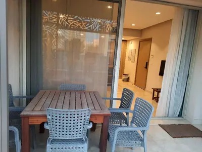 a wooden table and chairs on a patio at Mangroovy- 1br Imposing, Relaxing & Sea View in Hurghada