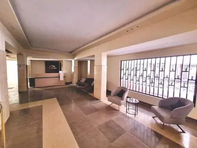 a lobby with chairs and a television in a building at Avenue Alhambra in Hurghada