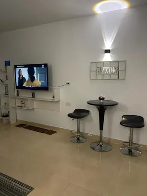 a room with two stools and a tv and a table at Avenue Alhambra in Hurghada