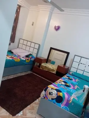 a bedroom with two beds and a mirror at Luxor in Luxor