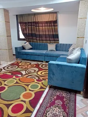 a living room with a blue couch and a rug at Luxor in Luxor