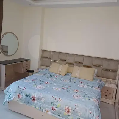 a bedroom with a large bed with a blue comforter at Mirage Bay Resort & Aqua Park in Hurghada