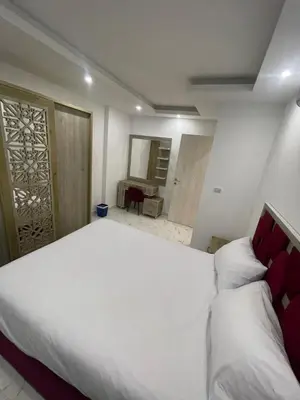 a bedroom with a large white bed and a bathroom at Fanadir Bay Compound in Hurghada