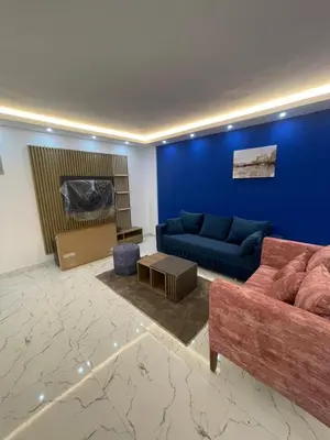 a living room with a couch and a blue wall at Fanadir Bay Compound in Hurghada