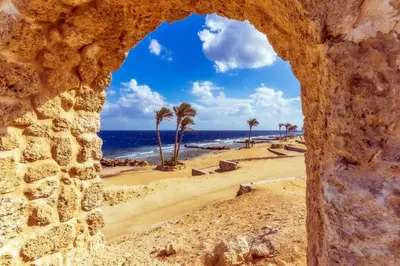 a view of a beach through a stone window at Resort-Style Luxury Chalet with Pool and Sea View in Sahl Hasheesh in Hurghada