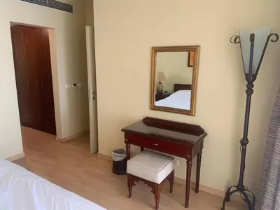 a bedroom with a desk and a mirror and a bed at Marina Bliss-Seaside Retreat in Marsa Alam
