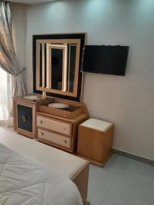 a bedroom with a dresser with a mirror and a bed at منتجع سكانديك in Hurghada