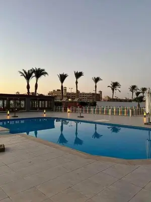 a large swimming pool with palm trees in the background at منتجع سكانديك in Hurghada