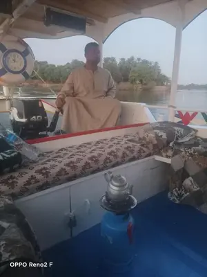 a man sitting in the back of a boat at Queen Sophie in Luxor