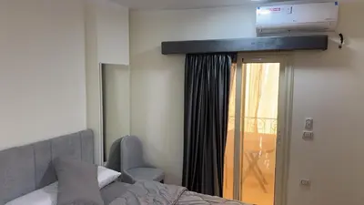 a bedroom with a bed and a television on the wall at Serenity Cozy Studio Direct to the Pool In Hurghada in Hurghada