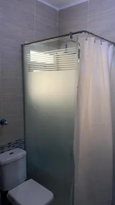 a bathroom with a toilet and a glass shower at Serenity Cozy Studio Direct to the Pool In Hurghada in Hurghada