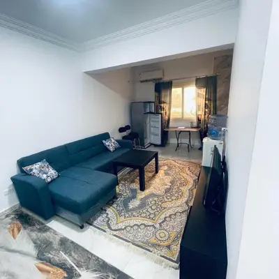a living room with a blue couch and a table at 1 plus 1 in city centre Hurghada in Hurghada