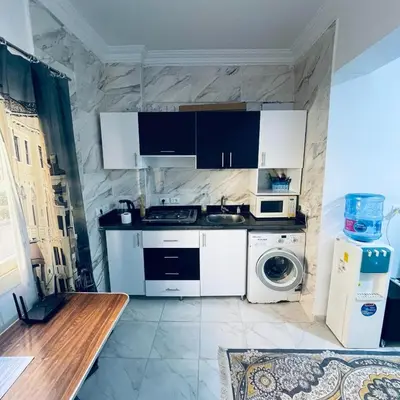 a kitchen with a stove and a washing machine at 1 plus 1 in city centre Hurghada in Hurghada