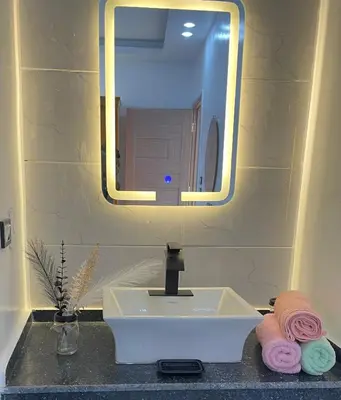 a bathroom sink with a mirror and pink towels at Fantasy home in Al Aqālitah