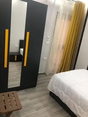 a bedroom with a bed and a yellow curtain at El Hadaba behind Raya in Hurghada