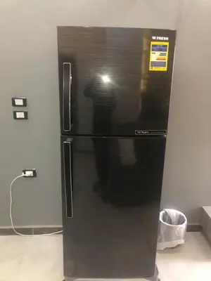a black refrigerator with a persons reflection in it at El Hadaba behind Raya in Hurghada