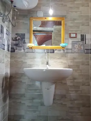 a bathroom with a white sink and a mirror at Nubian dream house in Jazīrat Fīlah