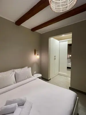 a bedroom with a large white bed with a chandelier at Luxury one bedroom in Hurghada