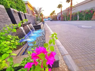 a small fountain in a street with pink flowers at Luxury one bedroom in Hurghada