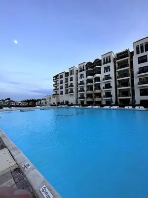 a large pool of blue water in front of buildings at studio in a 5 star hotel in Hurghada