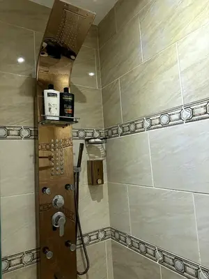 a bathroom with a shower with a wooden door at studio in a 5 star hotel in Hurghada