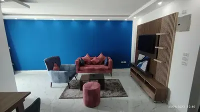 a living room with a couch and a blue wall at Fanadir Bay Resort in Hurghada
