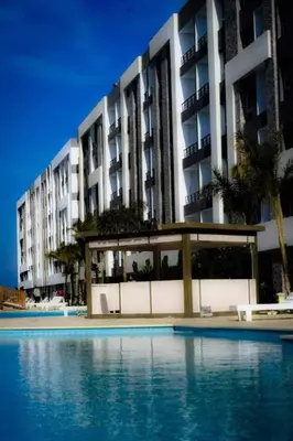 a large building with a swimming pool in front of it at Fanadir Bay Resort in Hurghada