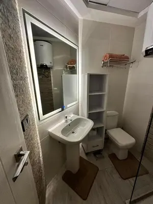 a bathroom with a sink and a toilet and a mirror at The best Studio in Hurghada