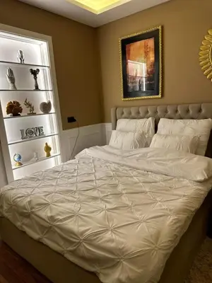 a bedroom with a white bed with a gold frame at The best Studio in Hurghada