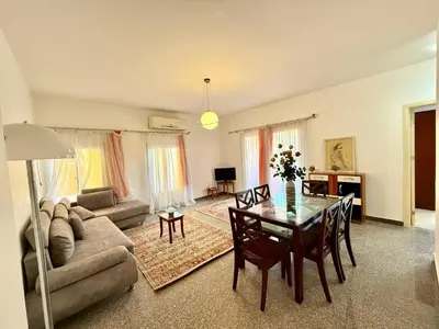 a living room with a table and a couch at Amazing 2BR Apartment - Al Dora Resort, Hurghada in Hurghada
