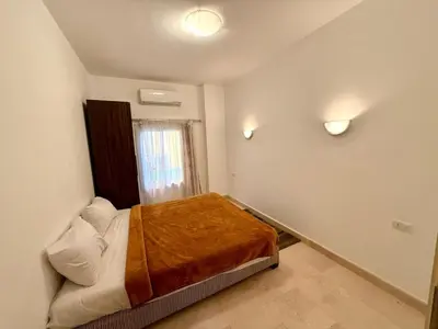 a small bedroom with a bed with a brown blanket at Amazing 2BR Apartment - Al Dora Resort, Hurghada in Hurghada